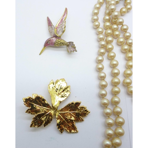 862 - A gilt metal collarette, a double strand faux pearl necklace, a bird brooch and a leaf brooch