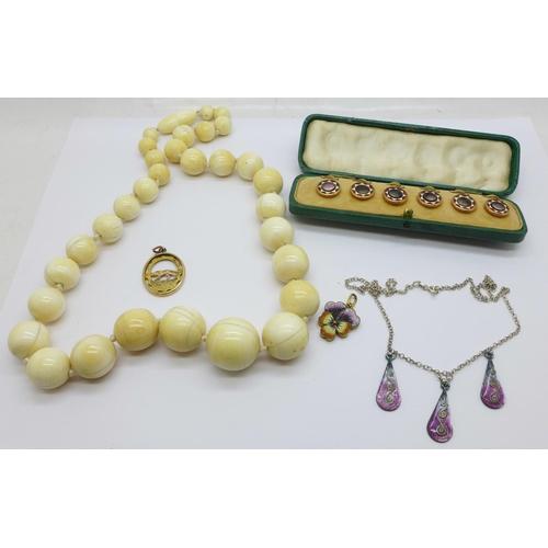 927 - An ivory bead necklace, a cased set of six enamelled studs, enamel necklace and two pendants