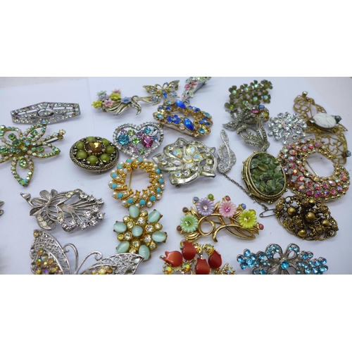 947 - A box containing approximately forty vintage costume brooches