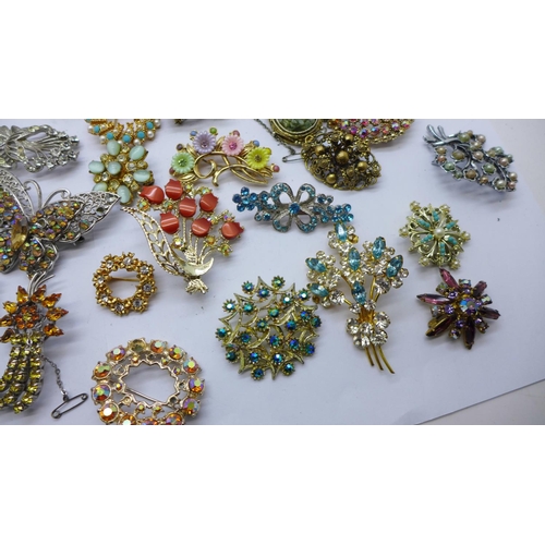 947 - A box containing approximately forty vintage costume brooches