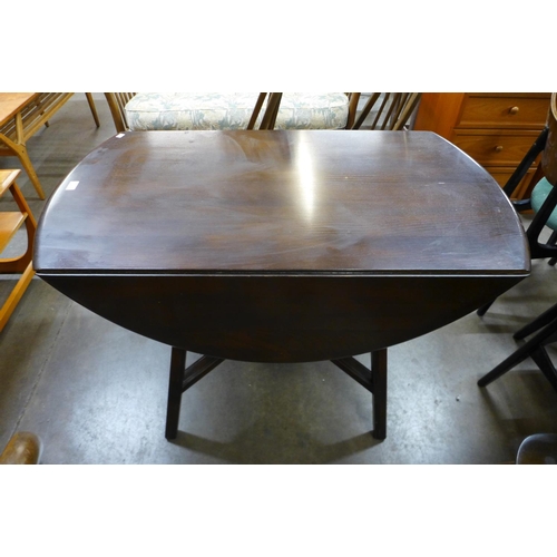 135 - An Ercol dark elm Windsor drop leaf table and four Quaker chairs