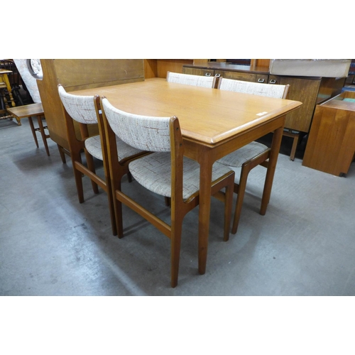 158 - A Danish teak extending dining table and four Eric Buch teak dining chairs