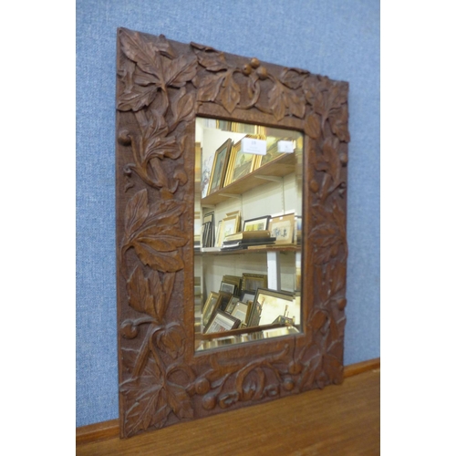 19 - A carved oak rectangular framed mirror, 54cms x 39cms