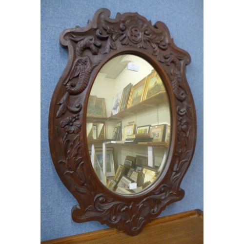 20 - A carved oak oval framed mirror, 72 x 50cms