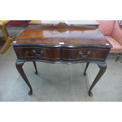 204 - A mahogany two drawer serpentine side table