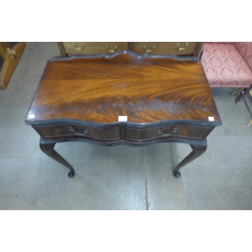 204 - A mahogany two drawer serpentine side table