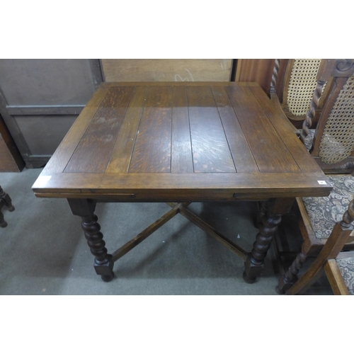 211 - An oak barleytwist draw-leaf table and three chairs