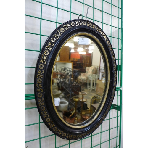 30 - A small Victorian ebonised and parcel gilt framed oval mirror