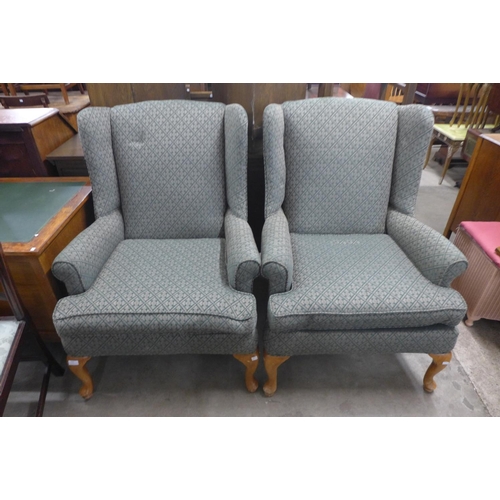 320 - A pair of walnut and upholstered wingback armchairs