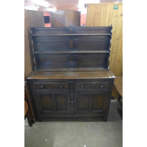 325 - An Ercol Old Colonial dark elm dresser, refectory table and six ladderback chairs