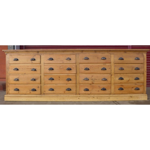 43 - A large pine sixteen drawer cabinet, 91cms h, 260cms w, 36cms d