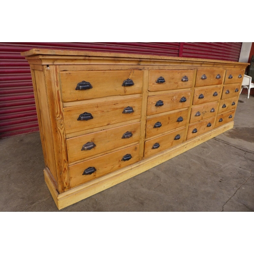 43 - A large pine sixteen drawer cabinet, 91cms h, 260cms w, 36cms d