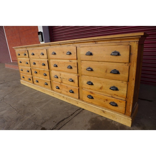 43 - A large pine sixteen drawer cabinet, 91cms h, 260cms w, 36cms d