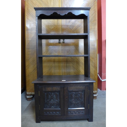 57 - An early 20th Century Jacobean Revival carved oak open bookcase, 130cms h x 68cms w