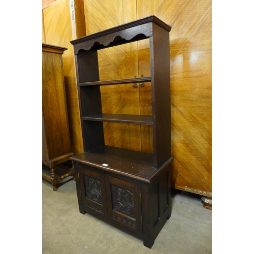 57 - An early 20th Century Jacobean Revival carved oak open bookcase, 130cms h x 68cms w