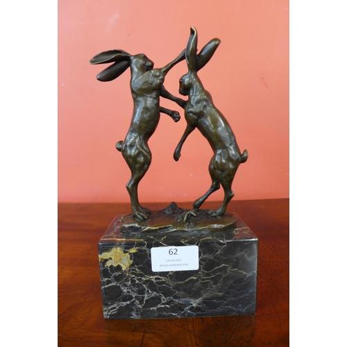 62 - A small French style bronze figure of boxing hares, on black marble socle, 24cms h