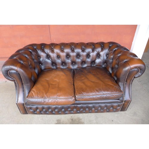 86 - A chestnut brown leather Chesterfield settee, 73cms h, 156cms w, 86cms d