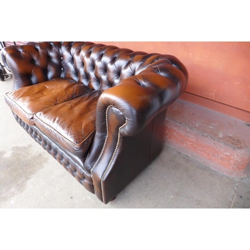 86 - A chestnut brown leather Chesterfield settee, 73cms h, 156cms w, 86cms d