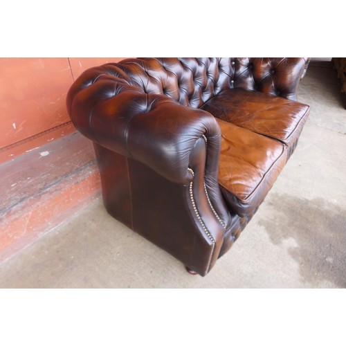 86 - A chestnut brown leather Chesterfield settee, 73cms h, 156cms w, 86cms d