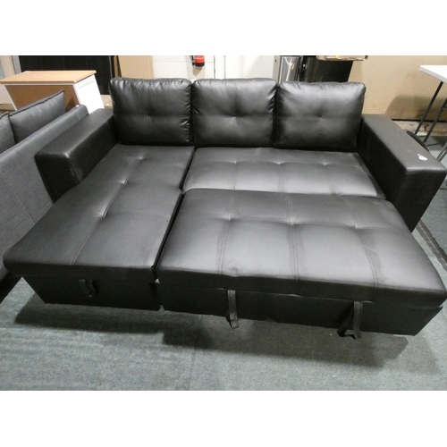 3083 - A black upholstered L-shaped sofa with pull-out bed and lift up ottoman storage * this lot is subjec... 