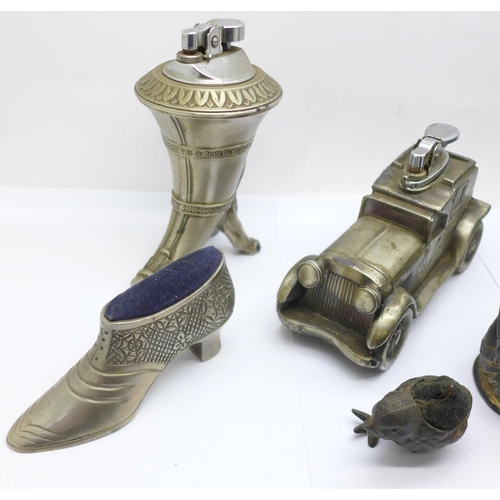 731 - Two novelty table lighters, two pin cushions, (chick a/f), a match holder and a gilt metal and bevel... 