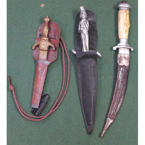 734 - Three daggers; one figural handle, one curved blade and one small brass