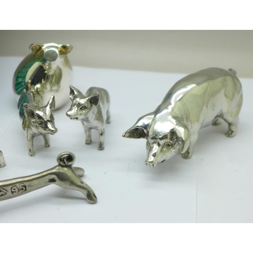 778 - A silver plated pig figure, pig knife rests, an enamel pill box, a pig game and other pig figures