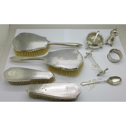 1042 - A silver salt, pepper, knife rest, napkin ring and two spoons, total weight 175g, and four silver ba... 