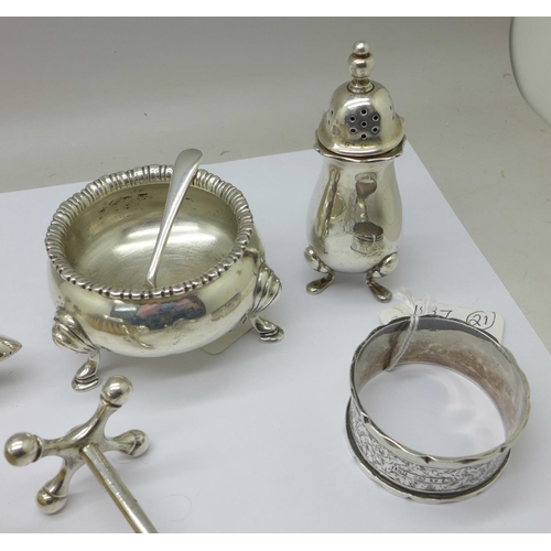 1042 - A silver salt, pepper, knife rest, napkin ring and two spoons, total weight 175g, and four silver ba... 