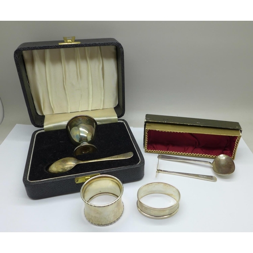 1043 - Two silver napkin rings, a silver feeding spoon and pusher and a silver egg cup and spoon, 110g, den... 