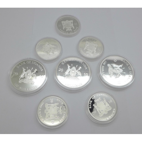 1201 - Eight coins;-three 2010 Bank of Uganda 100 shillings layered in silver, proof quality, Man Eaters, B... 