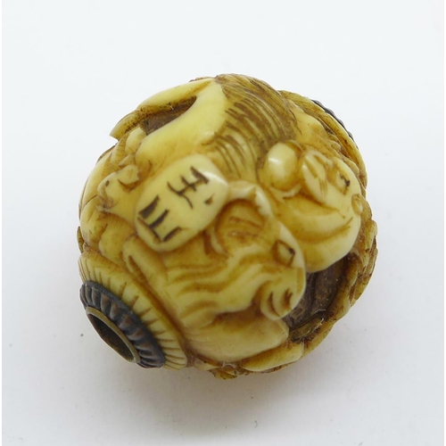 1215 - A Japanese Meiji period carved ivory ball/charm depicting animals, signed