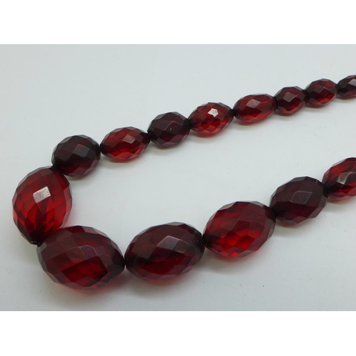 1229 - A string of faceted sherry amber coloured beads, 60cm