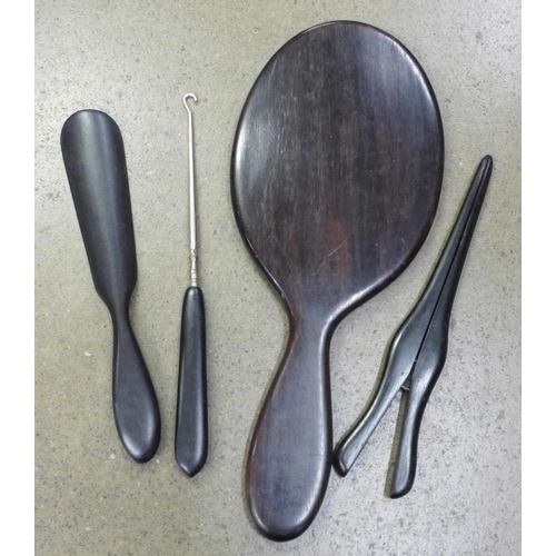 1271 - An ebony hand mirror, shoe horn, button hook and glove stretchers