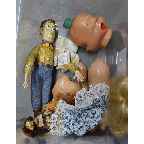 1300 - A box of soft toys and plastic dinosaur figures and two composition dolls in parts, a Woody doll (no... 