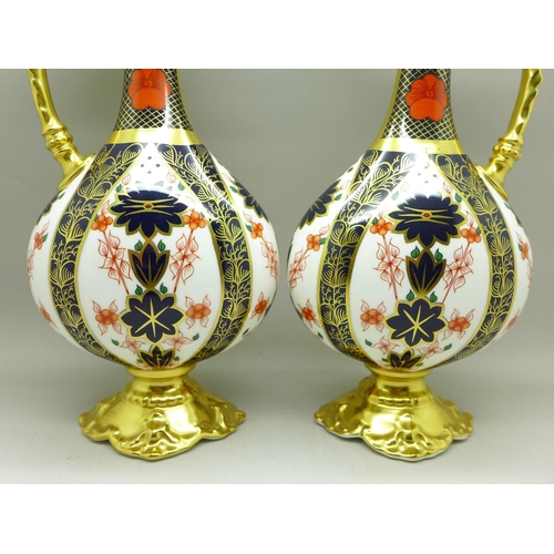 680 - A pair of Royal Crown Derby 1128 pattern ewers, 25.5cm, (one with hairline crack on the handle)