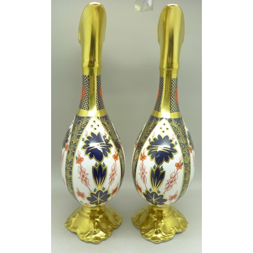 680 - A pair of Royal Crown Derby 1128 pattern ewers, 25.5cm, (one with hairline crack on the handle)