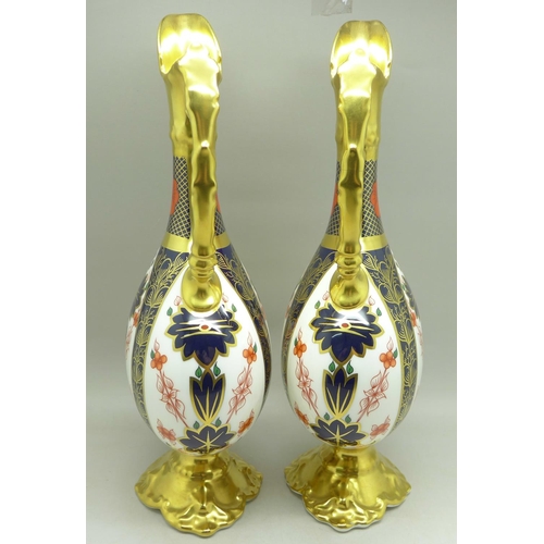 680 - A pair of Royal Crown Derby 1128 pattern ewers, 25.5cm, (one with hairline crack on the handle)