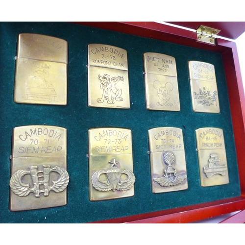 733 - Two cased sets of Zippo lighters, eight brass and twenty mixed, all bearing mottos or motifs