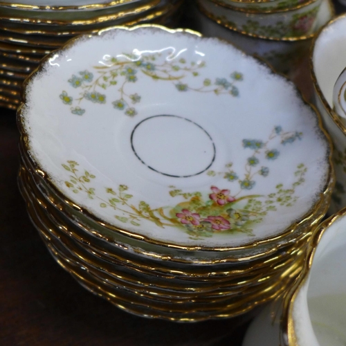 749 - An early 20th Century floral decorated tea service, 12 cups (two a/f), 11 saucers, 12 side plates, (... 