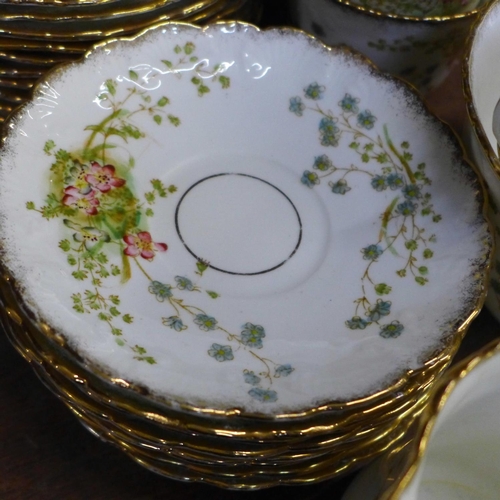 749 - An early 20th Century floral decorated tea service, 12 cups (two a/f), 11 saucers, 12 side plates, (... 