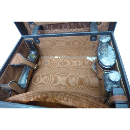 772 - A travel vanity case with four silver topped jars and two travel inkwells