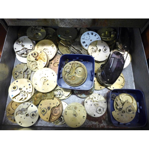 874 - A metal cabinet of watch movements in parts