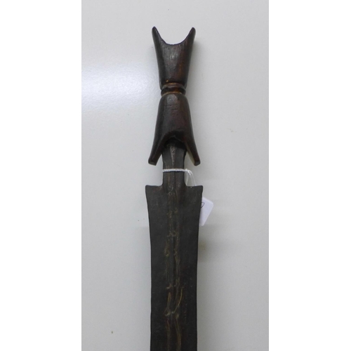 912 - An African tribal sword with wooden handle, etched blade, blade 75cm