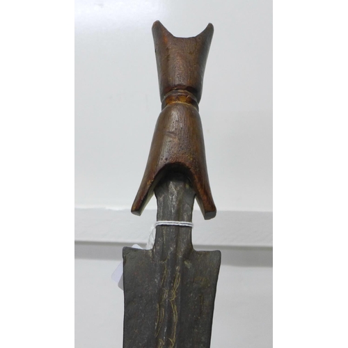 912 - An African tribal sword with wooden handle, etched blade, blade 75cm