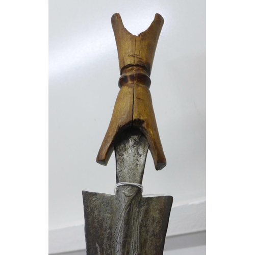 919 - An African tribal sword with wooden handle, etched blade, blade 69cm