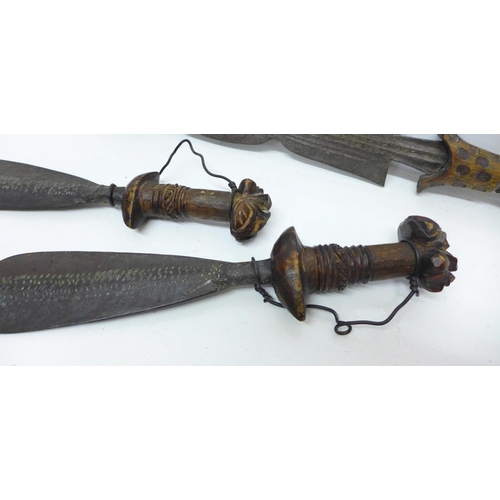 929 - An African tribal dagger and a pair of daggers with carved handles