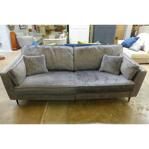 1552 - A grey crushed velvet three seater sofa  - Damaged under liner.