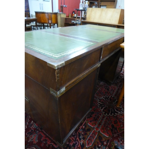 107 - A campaign style mahogany, brass mounted and green leather topped desk