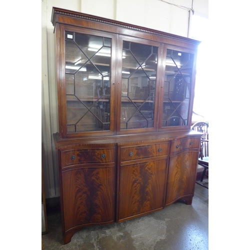 124 - A George III style inlaid mahogany serpentine library bookcase